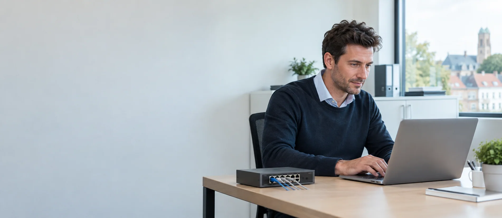 IT-medewerker controleert een laptop en netwerkapparatuur